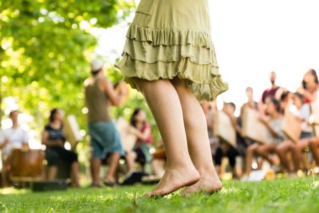 Crop girl dancing on grass